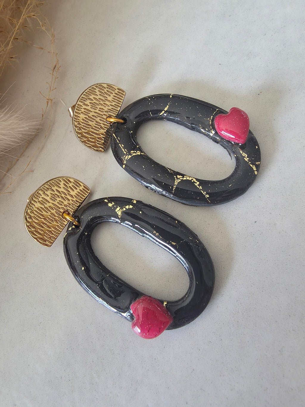 Boucles d'oreilles ovales en argile polymère – noir or & petit cœur rouge