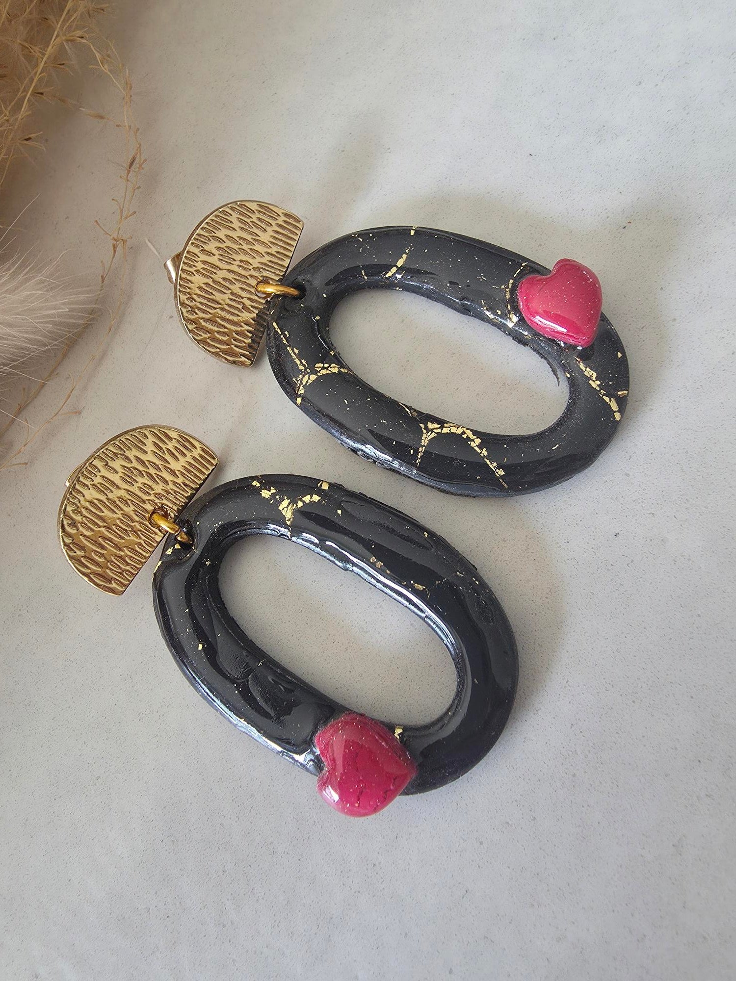 Boucles d'oreilles ovales en argile polymère – noir or & petit cœur rouge