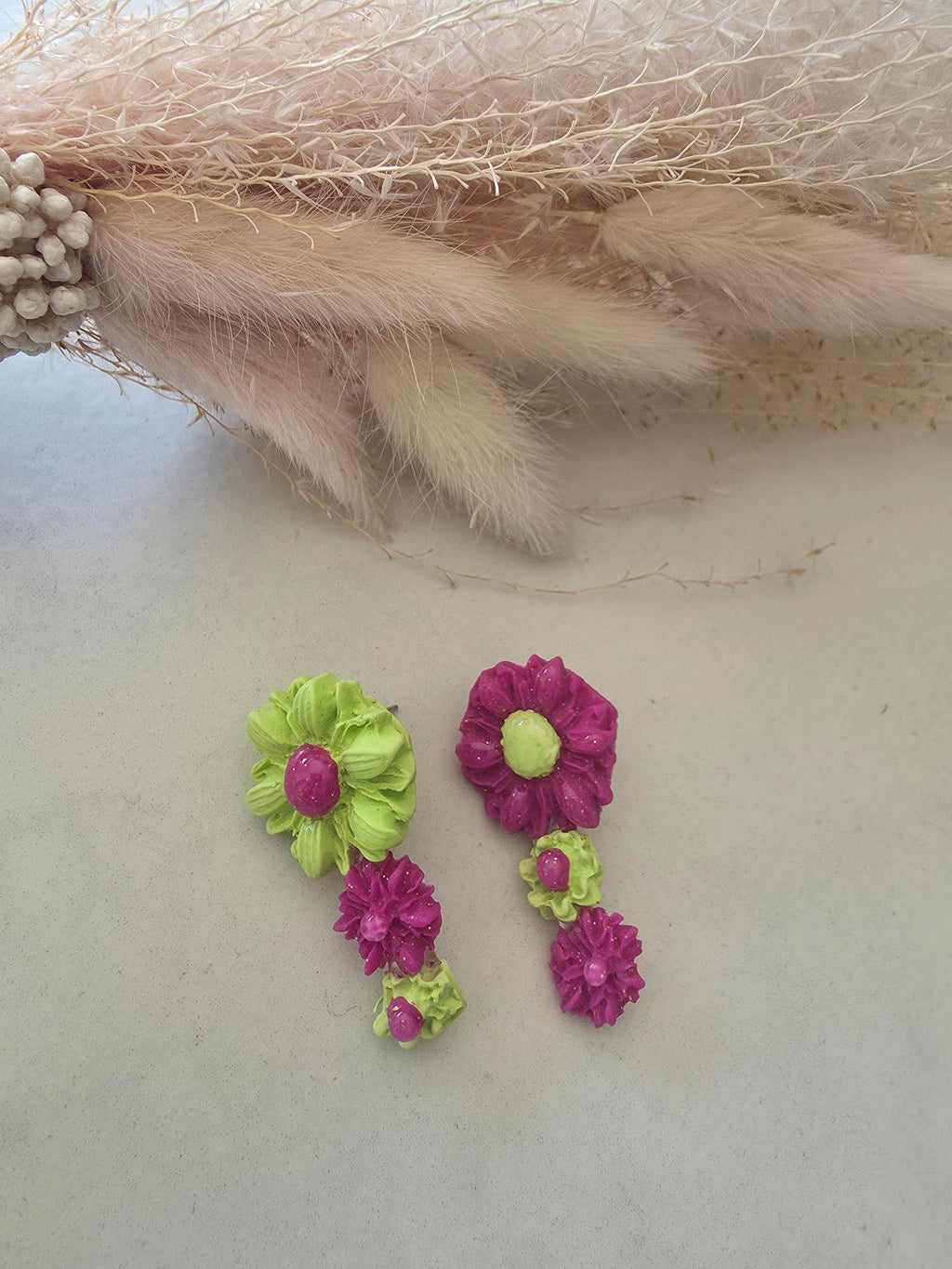 Boucles d'oreilles fleurs asymétriques vert anis & fuchsia en argile polymère