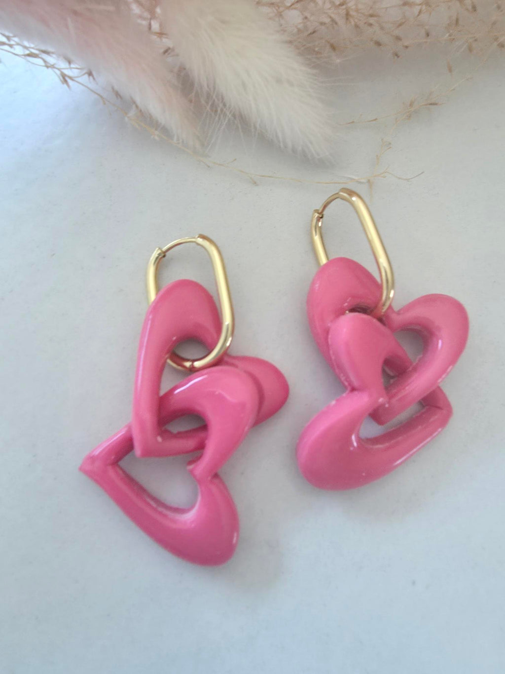 Boucles d'oreilles pendantes créole dorée – cœurs entrelacés en argile polymère rose (paire)