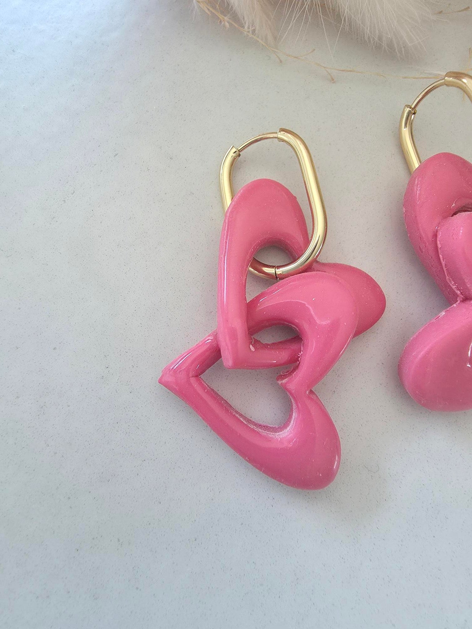 Boucles d'oreilles pendantes créole dorée – cœurs entrelacés en argile polymère rose (paire)